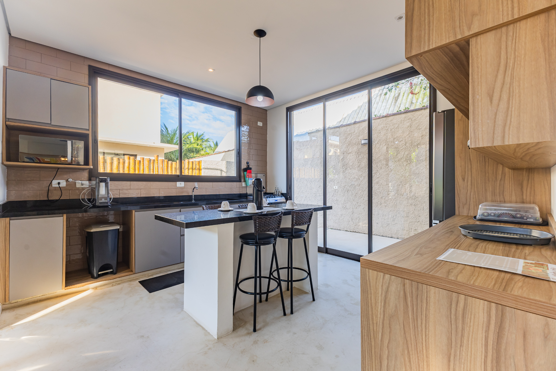 Cozinha integrada com ilha gourmet e amplas portas de vidro